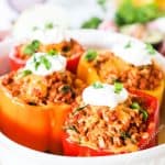 Mexican Stuffed Peppers topped with sour cream and cilantro
