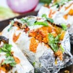BBQ Chicken Baked Potato Recipe topped with cheese, sour cream and cilantro.