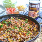 Ground Beef Sloppy Joes on a table with Manwich and toppings